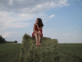 Full length of woman standing on field against sky