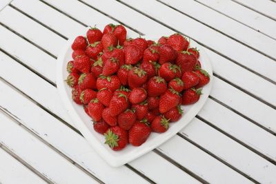 Close-up of strawberries in heart shape plate on table