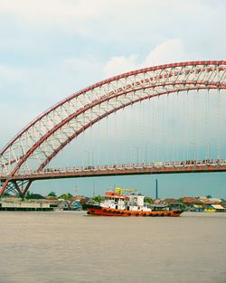 Suspension bridge over sea against sky