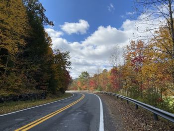 Curvy road with autumn colors an blue sky leading up to twin falls state park in west virginia