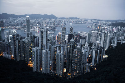 Illuminated modern buildings in city against sky