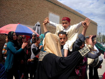 Group of people standing against built structure