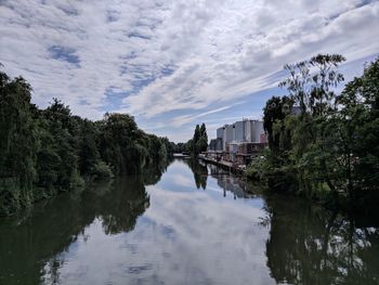 River amidst trees and buildings against sky