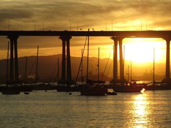 Silhouette of boats at harbor during sunset