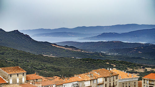 High angle view of townscape by mountains against sky