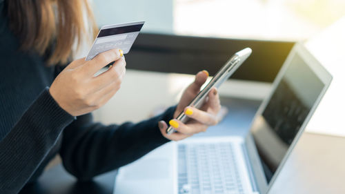 Midsection of woman using mobile phone