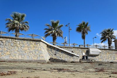 Low angle view of palm trees against clear blue sky