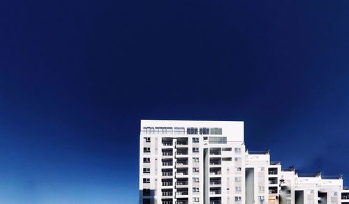 Low angle view of modern building against blue sky