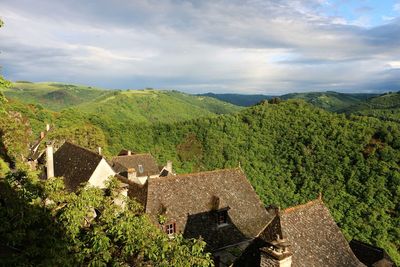 Scenic view of green landscape and mountains against sky