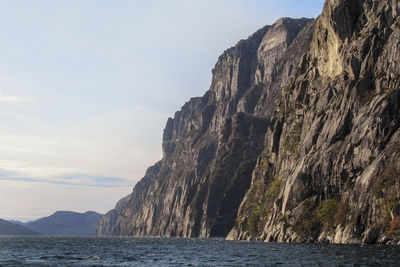 Rock formations by sea against sky