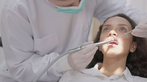 Midsection of dentist examining patient in clinic