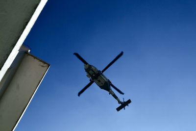 Low angle view of airplane against clear blue sky