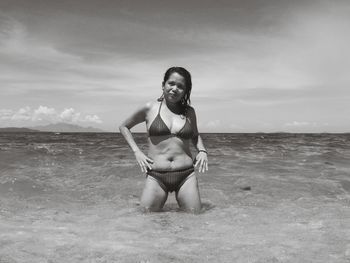 Woman in bikini at beach against sky