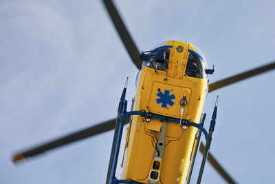 Low angle view of yellow crane against sky