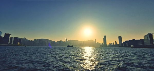 Panoramic view of sea and buildings against sky during sunset