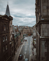 High angle view of cars on road amidst buildings in city against sky