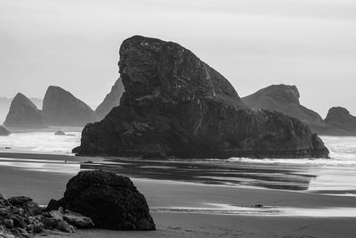 Rock formation on beach against sky