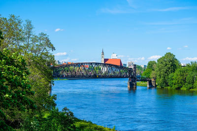 Arch bridge over river against sky