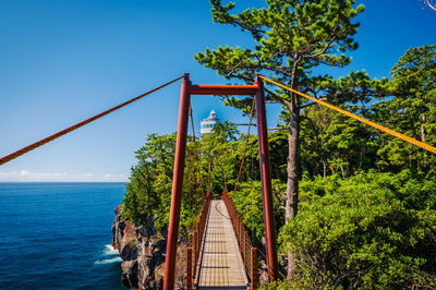 Bridge over sea against clear blue sky