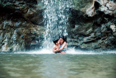 Full length of woman on rock in sea