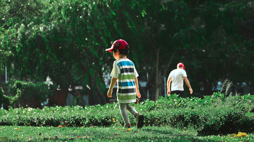 Rear view of people walking on grass