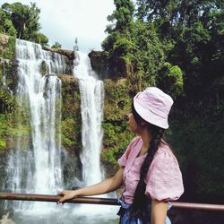 Woman looking at waterfall in forest