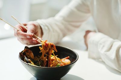 Midsection of person holding food in restaurant