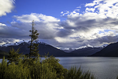 Scenic view of lake by mountains against sky