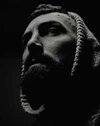 Close-up of man looking away against black background