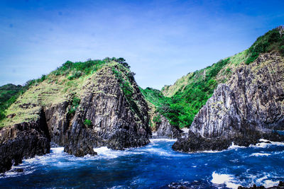 Scenic view of rocks in sea against sky