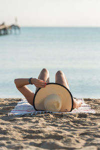 Rear view of woman sitting on beach