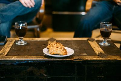 High angle view of black coffee and sweet food served on table at cafe