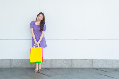 Full length of woman standing against the wall