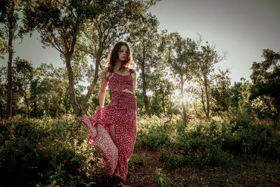 Young woman in the middle of a forest in long summer dress