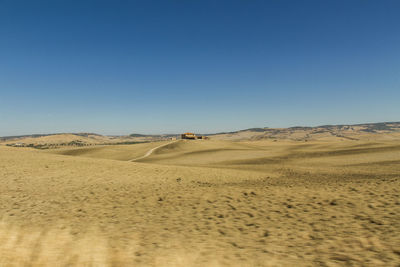 Scenic view of desert against clear blue sky