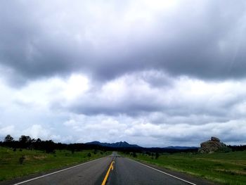 Empty road along countryside landscape