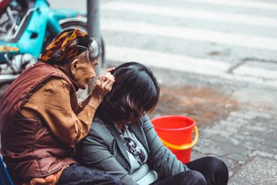 Midsection of couple sitting on street