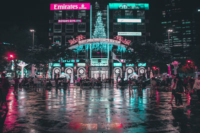Illuminated wet city street during rainy season at night