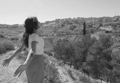 Black and white woman standing arms open breathing air exterior