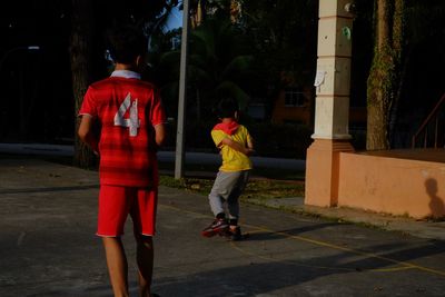 Rear view of people walking on street in city