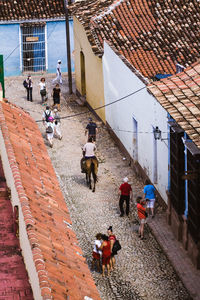 High angle view of people walking on street amidst houses