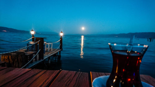 Close-up of wine on table against sea