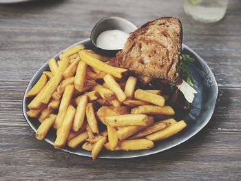 High angle view of meat and fries in plate on table