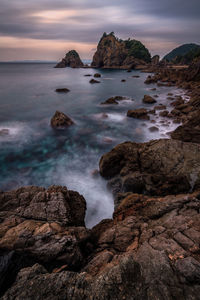 Scenic view of rocks in sea against sky