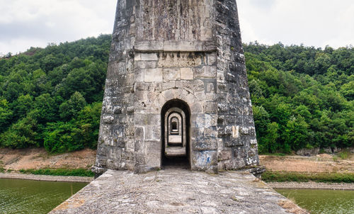 Stone wall of historic building against sky