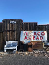 Information sign on old wall against clear blue sky