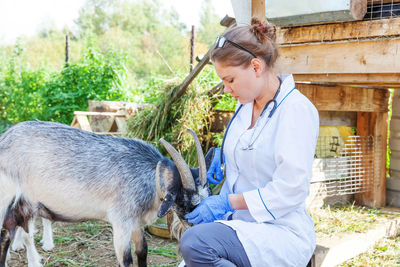 Side view of man with goat