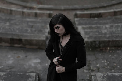 Beautiful young woman standing against wall