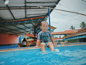 Full length portrait of happy boy in swimming pool