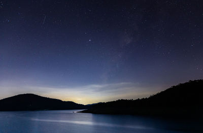 Scenic view of lake against sky at night